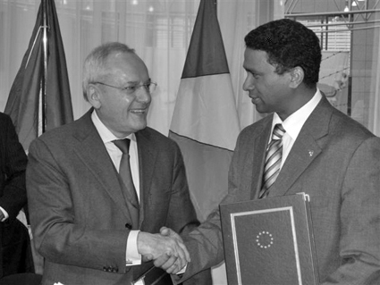 Ambassador Faure (right) shakes hand with the vice-president of the EC Jacques Barrot after signing the agreement