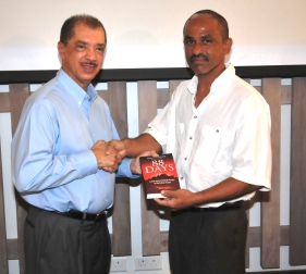 Capt Roucou presents a copy of his book to President Michel