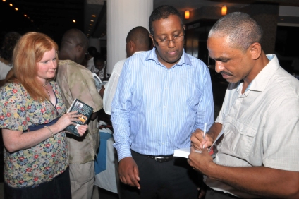 The author autographing copies of the book that guests had bought at the launch