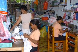 Rosalene Sinon (standing) runs a tailoring business at home where she employs two workers 