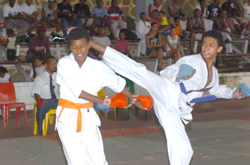 Mervin Servina (right) scores with a kick to Kilindo’s head in the 13-15 years old kumite final