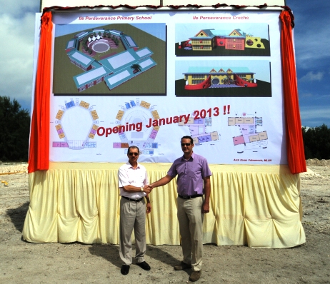President Michel and PS Lionnet shake hands after unveiling the project banner for the new school