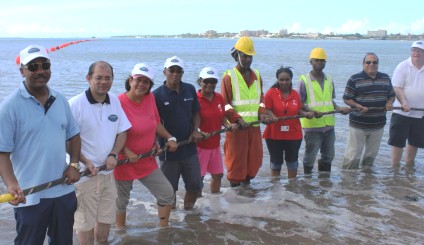 Minister Sinon leads the way by pulling the fibre optic cable ashore on Msasani beach accompanied by SCS’s representatives and partners in the project