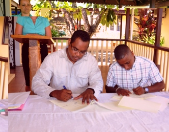 Mr Denousse and Mr Fanny sign documents marking the hand-over of the institution to the UniSey 