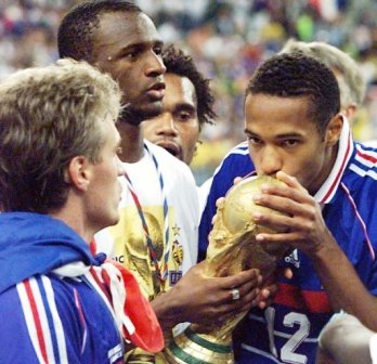 Thierry Henry embrasse la Coupe du Monde, entouré de Patrick Vieira (2ème de la gauche) et Didier Deschamps (gauche)
